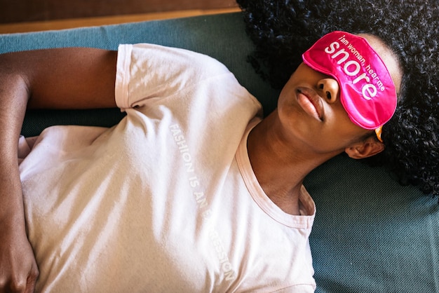 Young black lady using eye mask for sleep