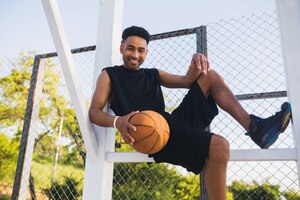 Young black man doing sports, playing basketball, active lifestyle, summer morning, smiling happy having fun