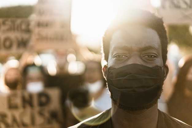 Young black man wearing face mask during equal rights protest
