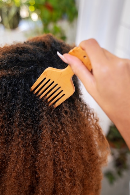 Giovane persona di colore che si prende cura dei capelli afro