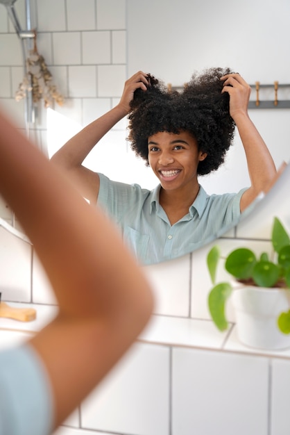 Foto gratuita giovane persona di colore che si prende cura dei capelli afro