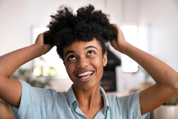 Foto gratuita giovane persona di colore che si prende cura dei capelli afro