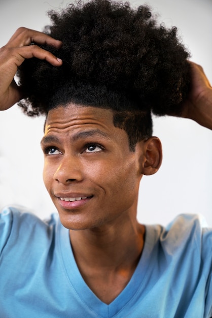 Молодой темнокожий человек ухаживает за афро-волосами