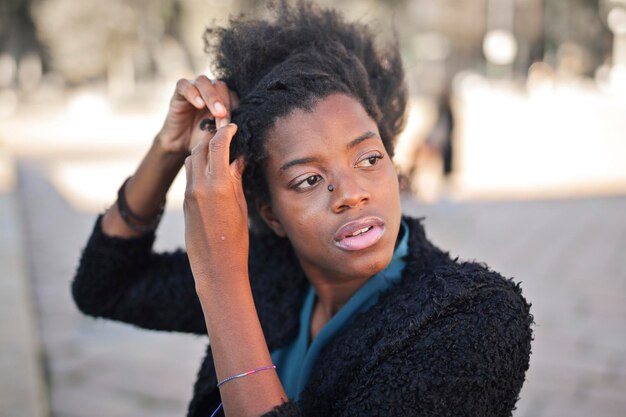 young black woman combs her hair