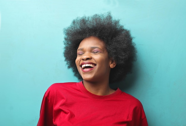 молодая негритянка смеется на синем фоне