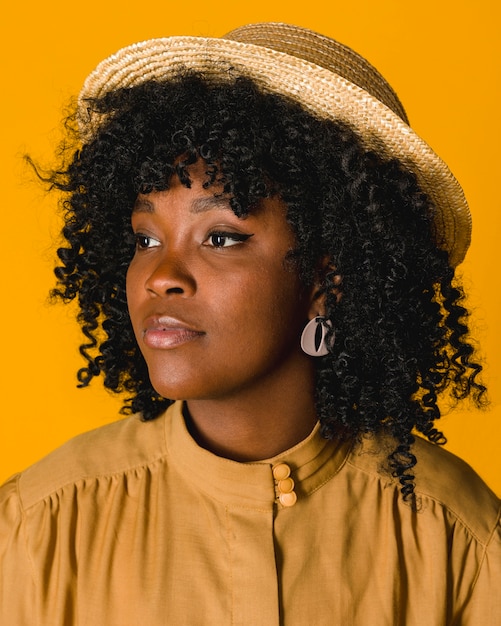 Free photo young black woman in straw hat looking away