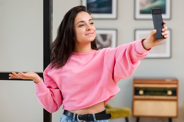 Young blogger holding her smartphone up