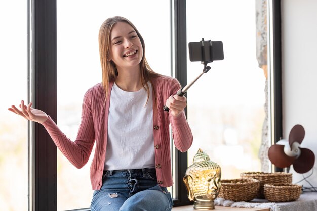 Young blogger recording herself next to window