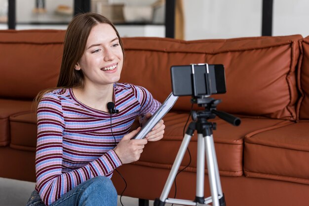 Young blogger recording herself with smartphone