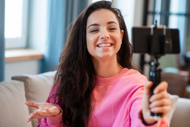 Young blogger recording herself with smartphone