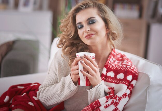 Молодая блондинка женщина пьет горячий шоколад