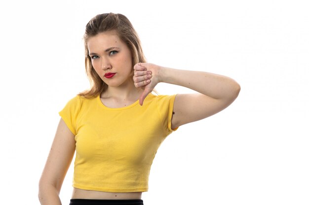 Young blond woman with yellow t-shirt gives thumb down