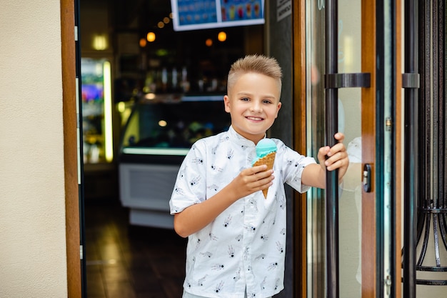 Молодой блондин мальчик с мороженым в руках Premium Фотографии