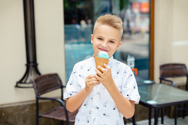 Молодой блондин мальчик с мороженым в руках Premium Фотографии
