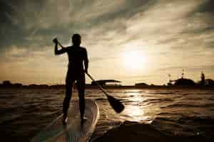 Free photo young blonde female on paddleboard at sea