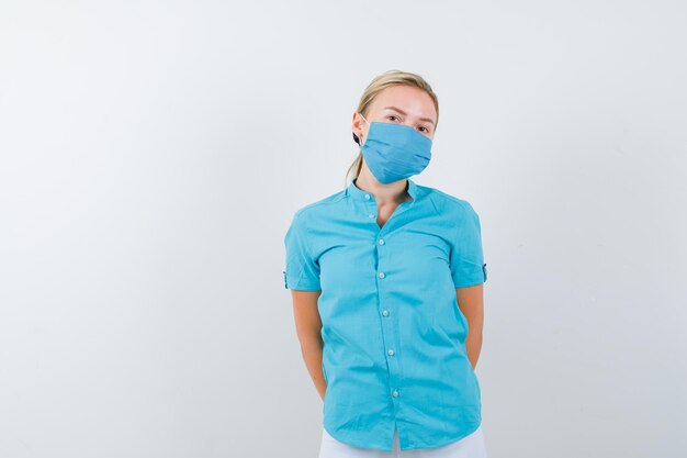 Free photo young blonde female posing while standing in casual clothes, mask and looking pensive