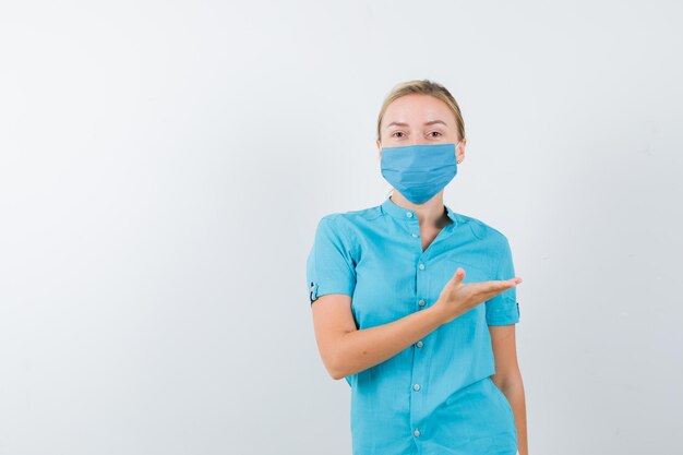 Young blonde female showing welcome gesture in casual clothes