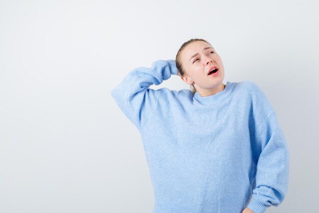 The young blonde girl is dreaming  on white background