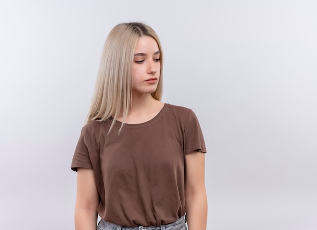 Young blonde girl looking at right side on isolated white wall with copy space