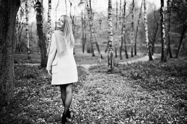 Free photo young blonde girl at pink coat posed on autumn park