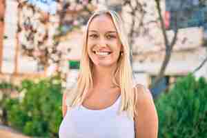 Free photo young blonde girl smiling happy walking at the park