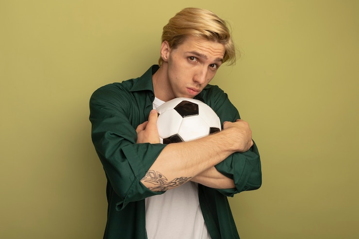 Free Photo young blonde guy wearing green t-shirt hugged ball