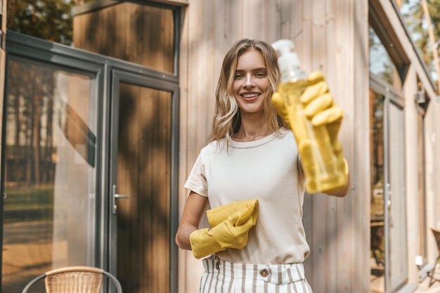 Young blonde housewife cleaning the house doors