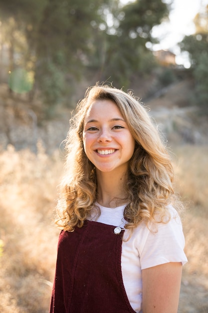 Free photo young blonde smiling while looking at camera on nature