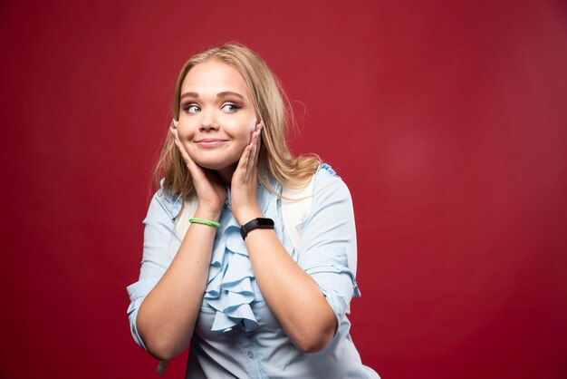 Young blonde student woman goes back to school and feels lovely and happy.