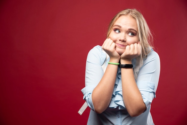 Young blonde student woman with her backpack goes back to school and feels lovely and happy.