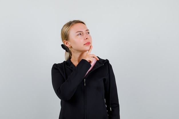 Young blonde woman in a black jacket