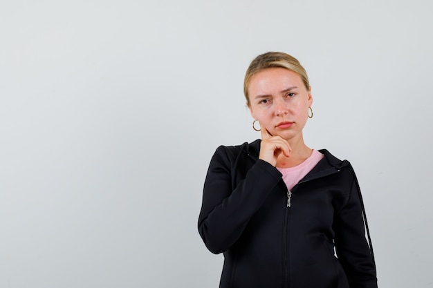 Young blonde woman in a black jacket