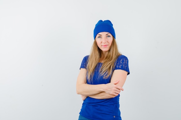 파란색 티셔츠와 모자를 쓴 젊은 금발 여성