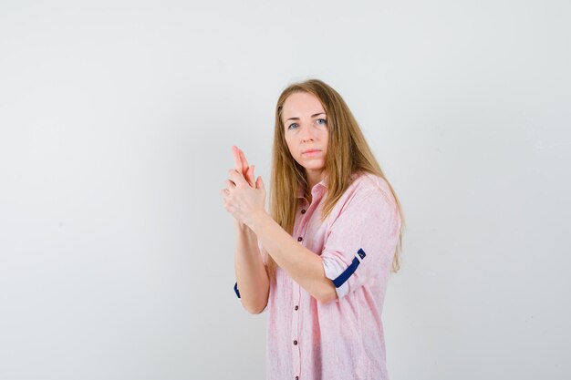 Young blonde woman in a casual pink shirt