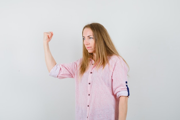 Giovane donna bionda in una camicia rosa casual