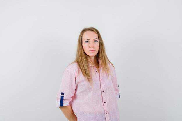 Young blonde woman in a casual pink shirt