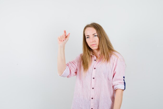 Young blonde woman in a casual pink shirt