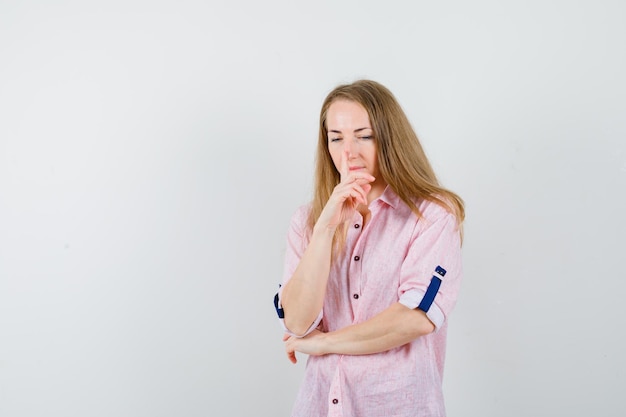 Giovane donna bionda in una camicia rosa casual