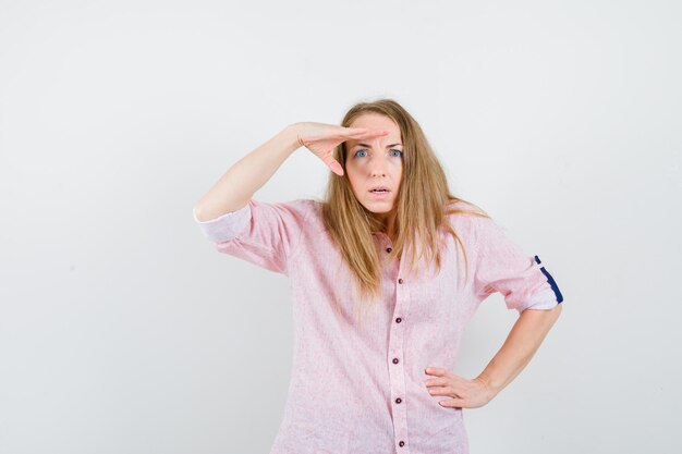 Young blonde woman in a casual pink shirt