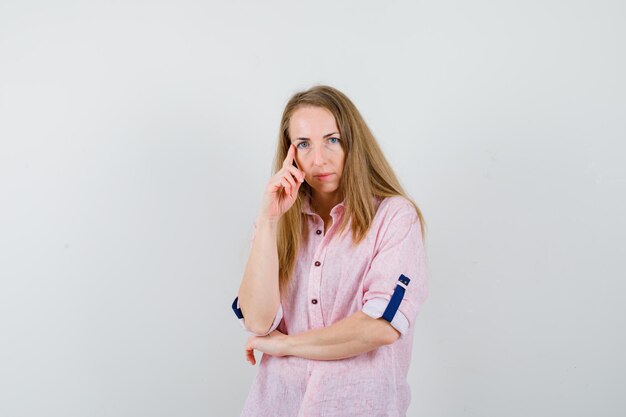 Young blonde woman in a casual pink shirt