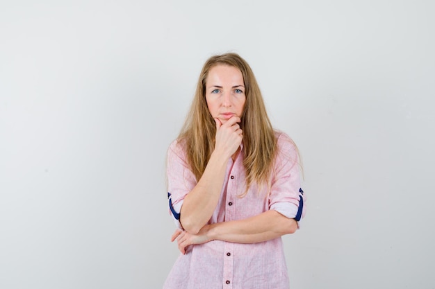 Young blonde woman in a casual pink shirt