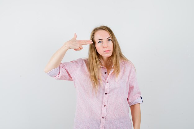 Young blonde woman in a casual pink shirt