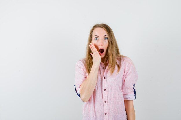 Young blonde woman in a casual pink shirt