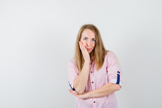 Free photo young blonde woman in a casual pink shirt