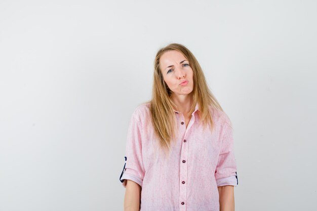 Young blonde woman in a casual pink shirt