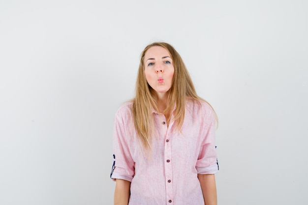 Free photo young blonde woman in a casual pink shirt