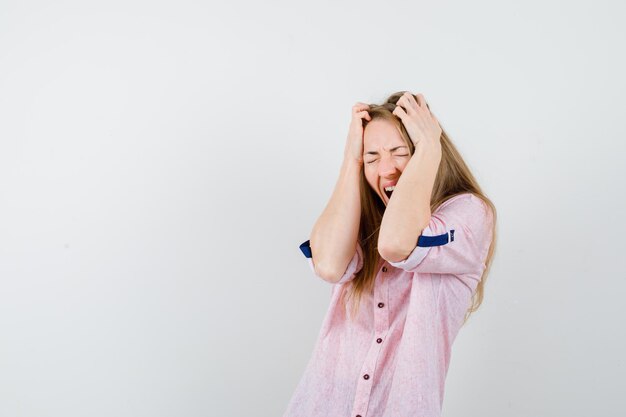 Young blonde woman in a casual pink shirt