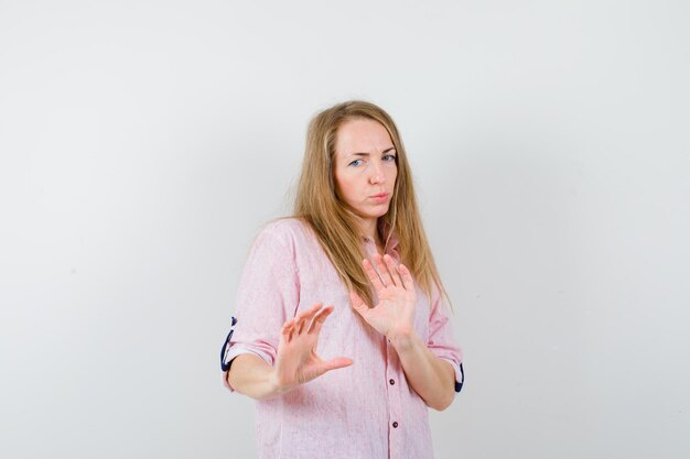 Young blonde woman in a casual pink shirt