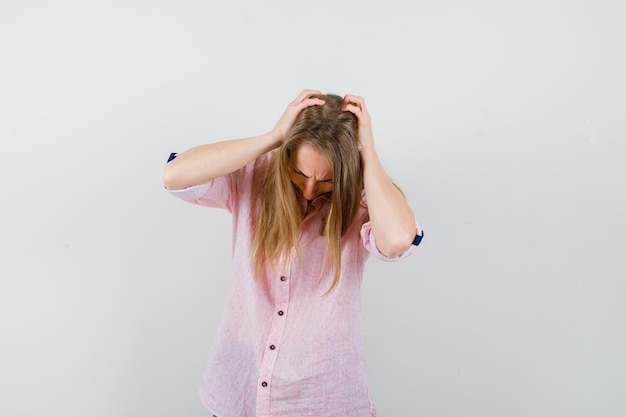 Young blonde woman in a casual pink shirt