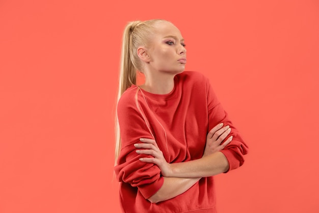 Young blonde woman on coral background